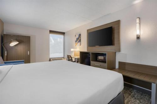 a hotel room with a bed and a flat screen tv at SureStay Plus Hotel by Best Western Chicago Lombard in Lombard