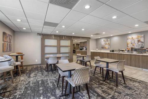 a waiting room with tables and chairs and a counter at SureStay Plus Hotel by Best Western Chicago Lombard in Lombard