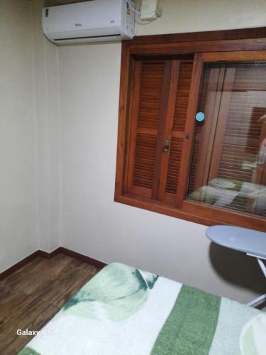 a room with a window and a table and a bed at Apartamento térreo fundos in Torres