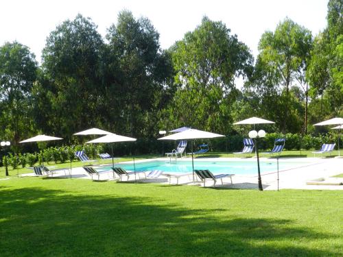 uma piscina com cadeiras e guarda-sóis em Il Nibbio Reale Country House em Rocca dʼEvandro