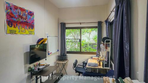 a room with a desk and a television and a window at Choose from 3 Distinct Character Houses with Soft Beds, Cozy Balconies and Bonuses in Haad Pleayleam