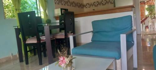 Una silla azul en una habitación con una mesa. en DLuchy Casa Finca Rural cerca al mar, en San Bernardo del Viento