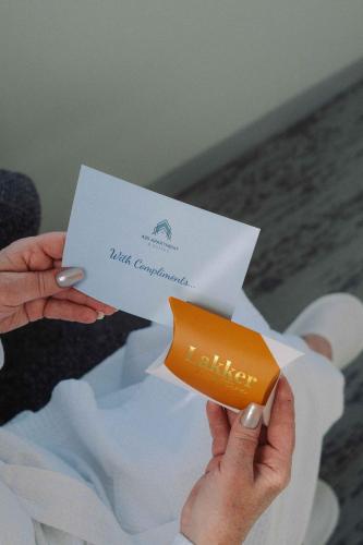 a person holding an orange card in a white envelope at 429 Apartments & Suites in Hobart
