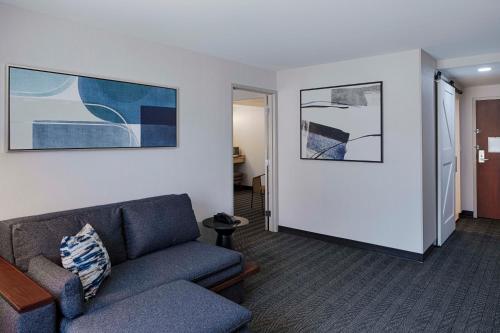 a living room with a couch and paintings on the wall at Courtyard by Marriott Springfield Downtown in Springfield