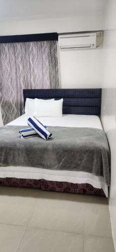a bed with two blue and white towels on it at Mead Road Homestay Tours & Transfers Studio in Suva