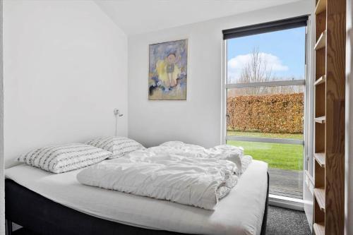 a white bedroom with a large bed and a window at OH534-Hadsund-Haslevgarde-Eng-2 in Hadsund