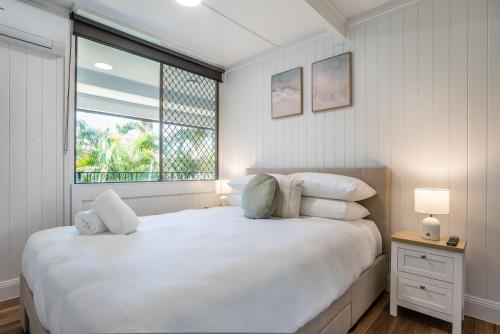 a white bedroom with a large bed and a window at Kangaroo Point Oasis Getaway Spacious and modern in Brisbane