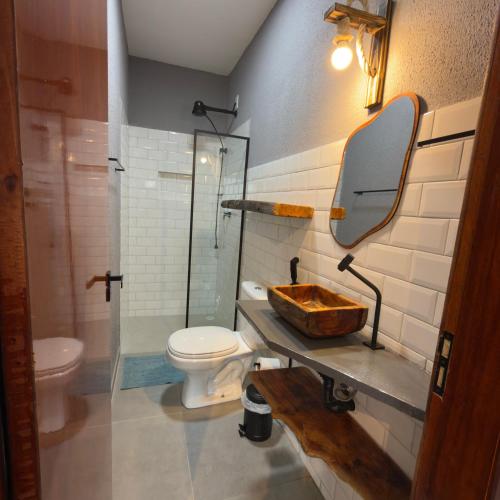 a bathroom with a sink and a toilet and a mirror at Bangalô Miramar Maragogi in Maragogi