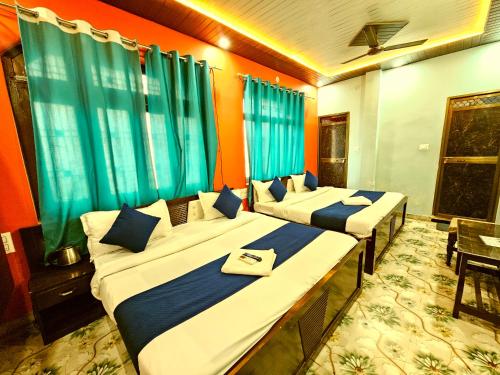 two beds in a room with green curtains at Suryakulam palace in Ayodhya