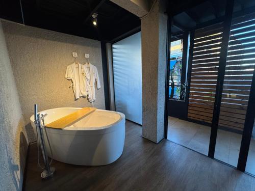 a bath tub in a room with a shirt hanging on a wall at Hotel Casa Leon Rooftop in Rionegro