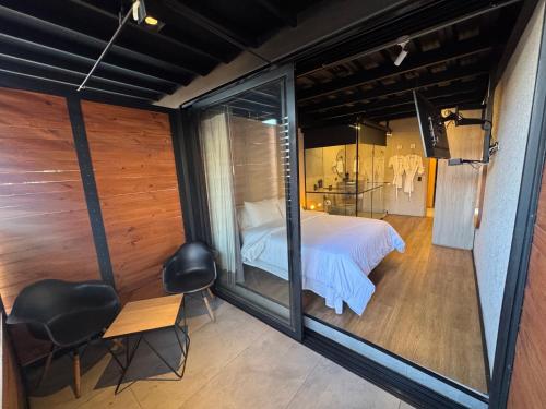a room with a bed and a glass wall at Hotel Casa Leon Rooftop in Rionegro