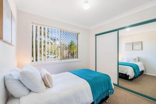a bedroom with a bed and a window at Banksia on Ocean in Evans Head