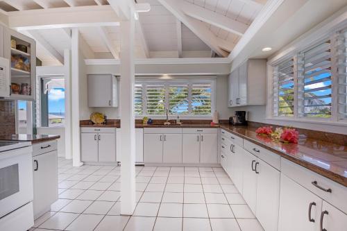 a kitchen with white cabinets and a white tile floor at Big Island Retreat - No Resort Fees in Kailua-Kona