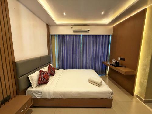 a bedroom with a bed and a window with purple curtains at Pokhara Backpackers Hostel in Pokhara