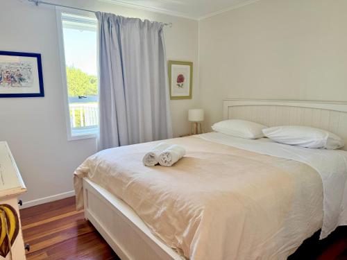 a bedroom with a large bed with towels on it at 'Noni's House' Coastal Opononi Hokianga in Opononi