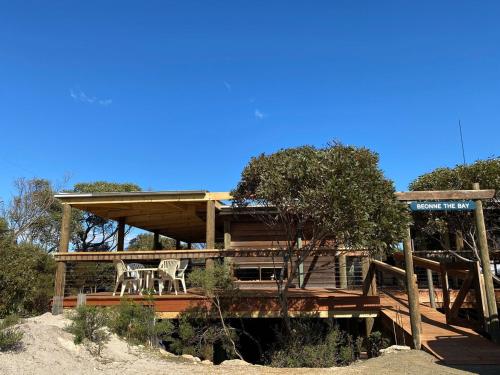 a house with a deck with two chairs on it at Beonne the Bay at Vivonne Bay, Kangaroo Island in Vivonne Bay