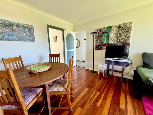a living room with a wooden table and a desk at 'Noni's House' Coastal Opononi Hokianga in Opononi