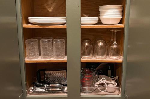 a cabinet with plates and bowls and other dishes at Timber Haven Aframe Cabin - Brand New Hot Tub in Friendship