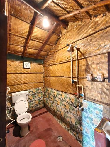 a bathroom with a toilet and a shower at Hampi's Dream Cottage in Hampi