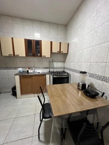 a kitchen with a wooden table and a stove at Casa Santa Cruz do Capibaribe in Santa Cruz do Capibaribe