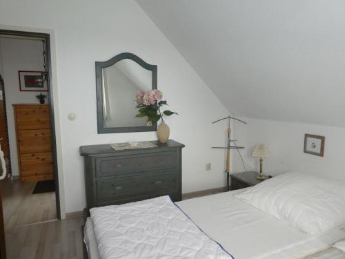 a bedroom with a bed and a dresser with a mirror at One-bedroom apartment in Heiligenhafen