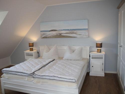a bedroom with a white bed with two night stands at Holiday apartment in Baabe with swimming pool in Baabe