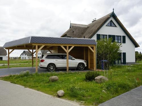 a car parked under a pavilion in front of a house at Holiday home in Vaschvitz with sauna in Vaschvitz