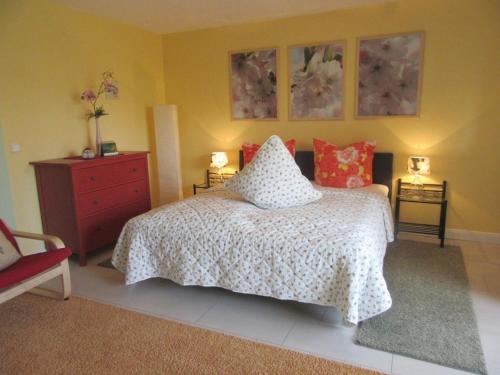 ein Schlafzimmer mit einem Bett und zwei Bildern an der Wand in der Unterkunft One-bedroom apartment in Otterndorf