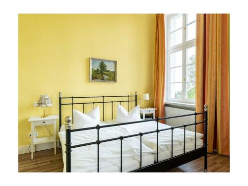 a bedroom with a bed with white pillows and a window at Groß Helle Manor House in Wrodow