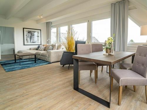 ein Wohnzimmer mit Tisch und Stühlen in der Unterkunft One-bedroom apartment in Munkmarsch