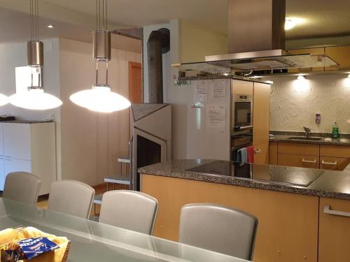 a kitchen with white chairs and a counter top at Holiday home with 2 bedrooms in Im Esch
