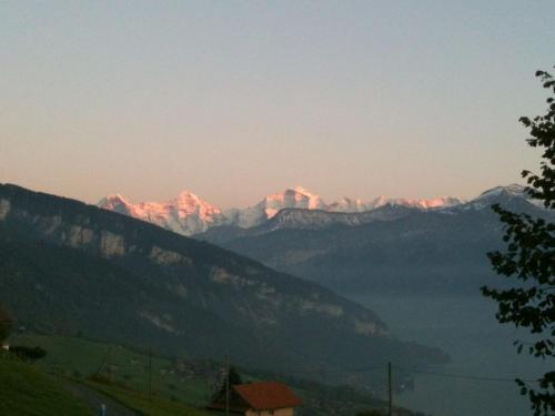 a view of a mountain range at sunset at Holiday Apartment Chalet Mooshang in Aeschlen ob Gunten