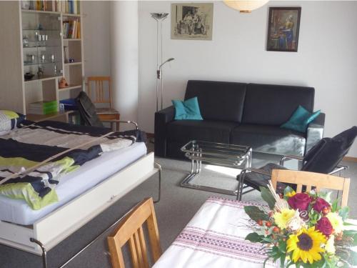a living room with a couch and a table at Holiday Apartment Chalet Mooshang in Aeschlen ob Gunten