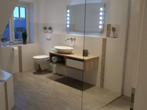 a bathroom with a sink and a toilet at Holiday home with 4 bedrooms in Wittendün