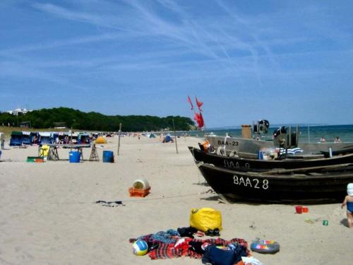 a boat on a beach with people on the sand at Storchensicht - Apartment with sauna in Losentitz