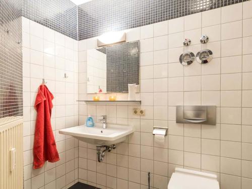 ドレスデンにあるApartment in Dresden with swimming poolの白いタイル張りのバスルーム(洗面台、トイレ付)