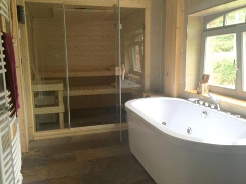 a large bathroom with a tub and a shower at Holiday home with 3 bedrooms in Tewswoos