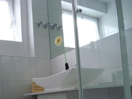 ボルクムにあるOne-bedroom apartmentの浴室の洗面台に置かれた花瓶と花