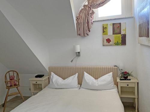 a bedroom with a bed with two pillows and a window at Wellness Residence Apartment 19 in Zingst