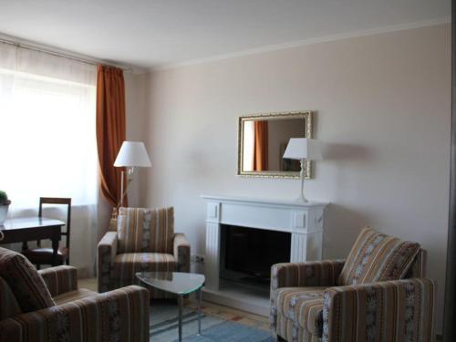 a living room with two chairs and a fireplace at One-bedroom apartment in Borkum