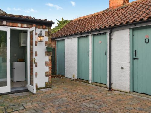 a group of three garages with blue doors at Puffin's Nest - Uk48474 in Flamborough