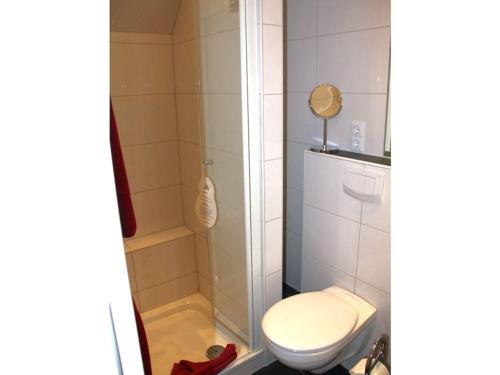 a small bathroom with a toilet and a shower at One-bedroom apartment in Borkum