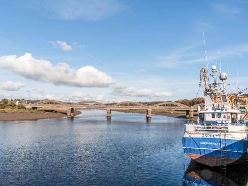 a boat in the water with a bridge in the background at Auchengool House in Kirkcudbright