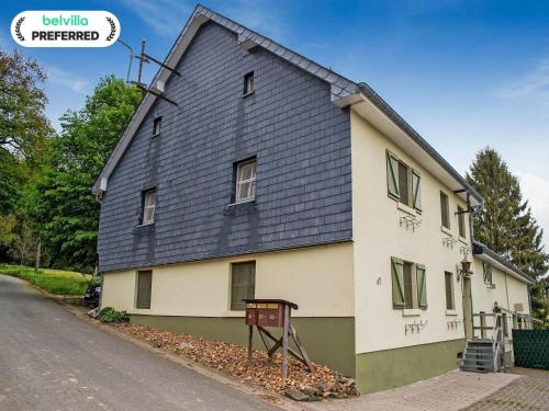 a house with a black roof on a street at Holiday Home near Ravel Cycling paths in Heuem