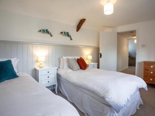 a bedroom with two beds and two lights on the wall at The Old Farmhouse in South Chard