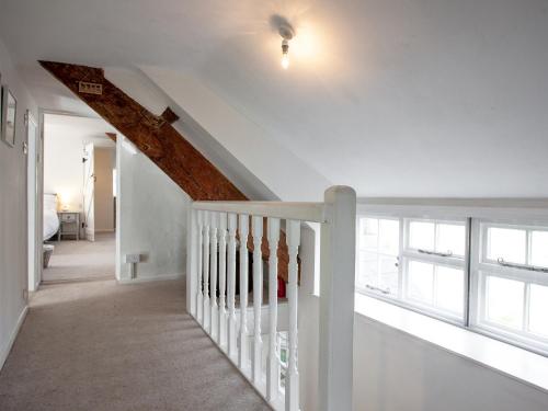 a white staircase in a home with a window at The Old Farmhouse in South Chard
