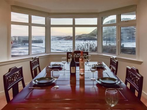 a dining room table with a bottle of wine and glasses at The Cliff in Ellon