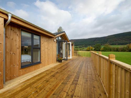 a wooden deck next to a house at Karelia Lodge in Kenmore