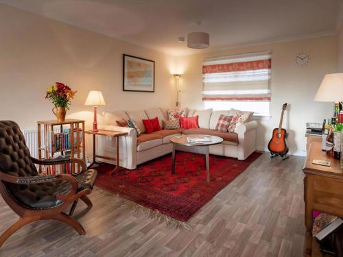 a living room with a white couch and a red rug at Grant Crescent in Dornoch