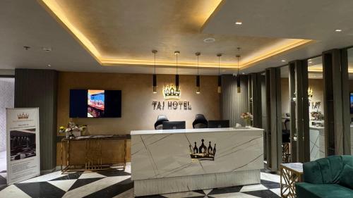 a hotel lobby with a reception desk and a tv at Taj Hotel Premium Residency F-7 Islamabad in Islamabad